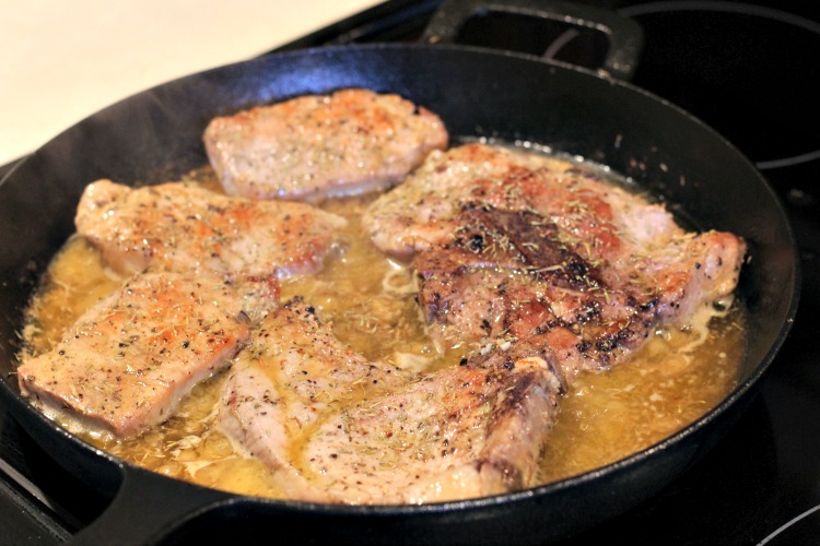 Garlic Butter Cast Iron Pork Chops  almost done cooking in skillet on stove top