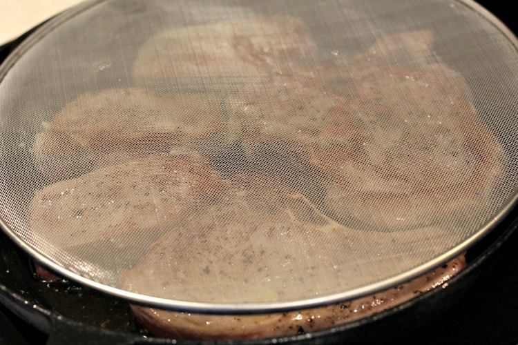 Bacon Splatter screen on skillet with pork chops cooking