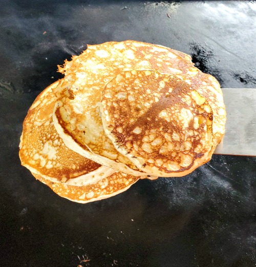 Blackstone Griddle Pancakes cooking on Blackstone with spatula under it 