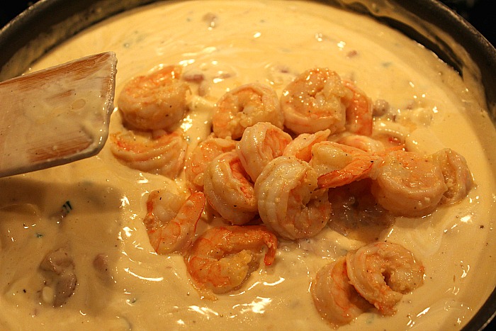 Shrimp Being added to alfredo sauce for ultimate chicken alfredo