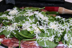 Flank Steak with Baby Spinach and cheese on it