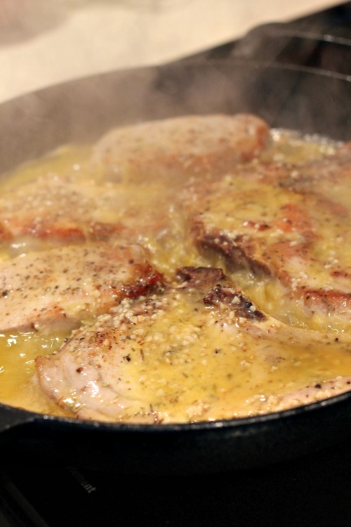 Garlic Butter Pork Chops Cooking in cast iron Skillet