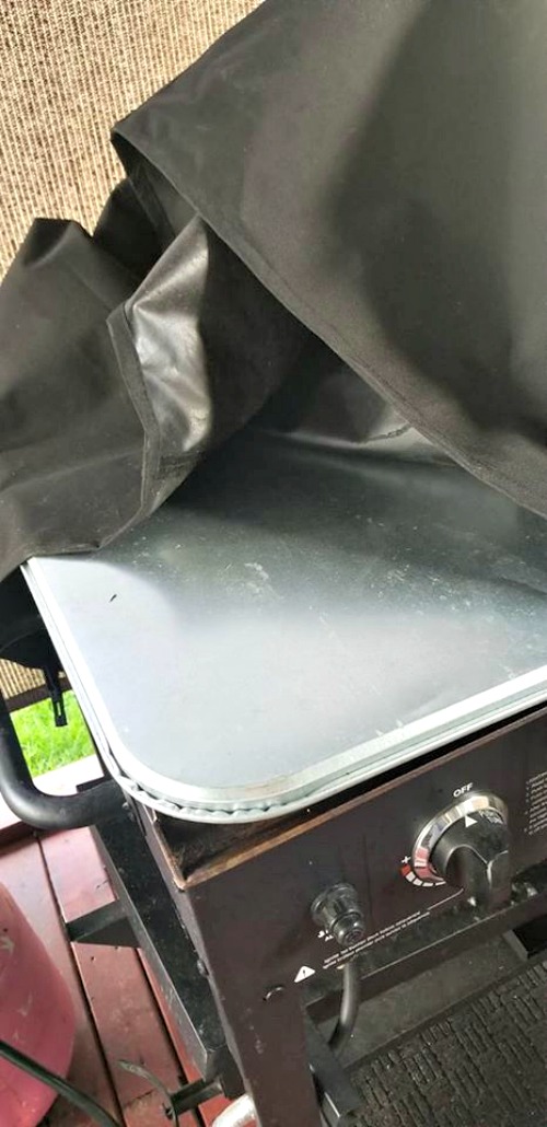 Car Oil Pan on top of 36 inch blackstone with canva cover