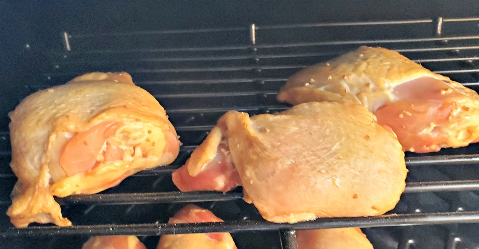 Coca Cola Chicken Thighs cooking on top rack of grill