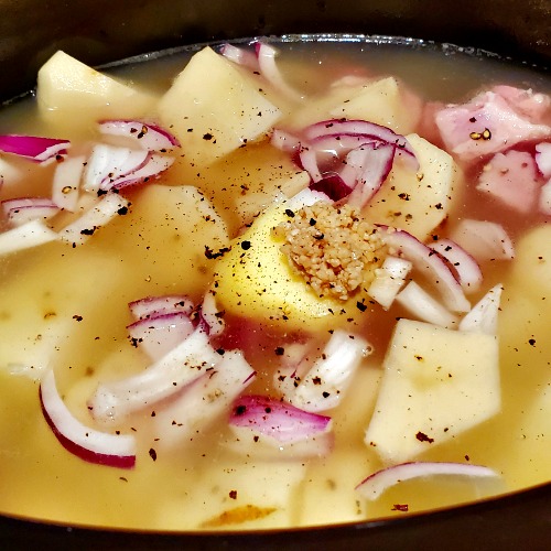Potatoes, ham, onions, and seasonings for ham and potato soup recipe in crockpot