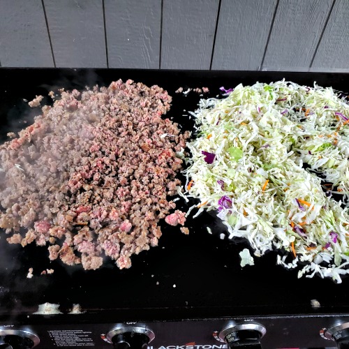 Cooked Ground Pork Sausage and coleslaw on blackstone griddle 