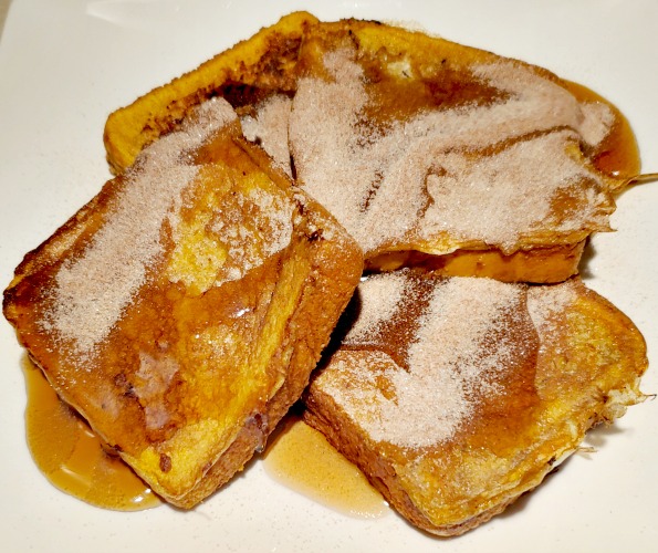 French Toast On Blackstone Griddle served on a plate with cinnamon sugar on it 