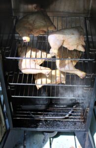 Coca Cola Leg Quarters smoking in vertical smoker