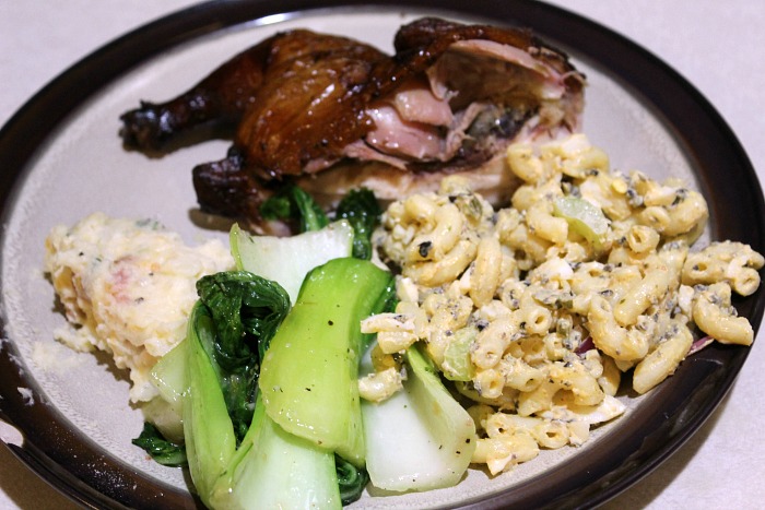 smoked cornish game hens served with pasta salad, and bok choy 