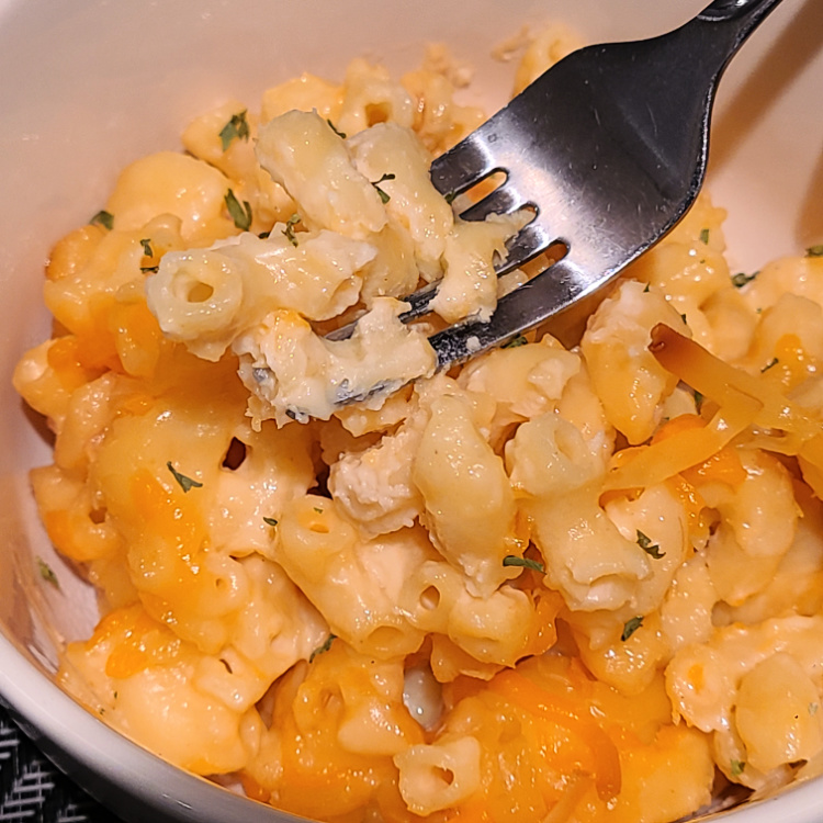Smoked macaroni and cheese in white bowl with a fork