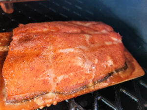 Smoked Brown sugar salmon on smoker on a cedar plank