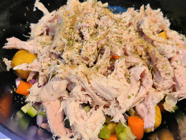 Seasoned smoked turkey in dutch oven with cut vegetables