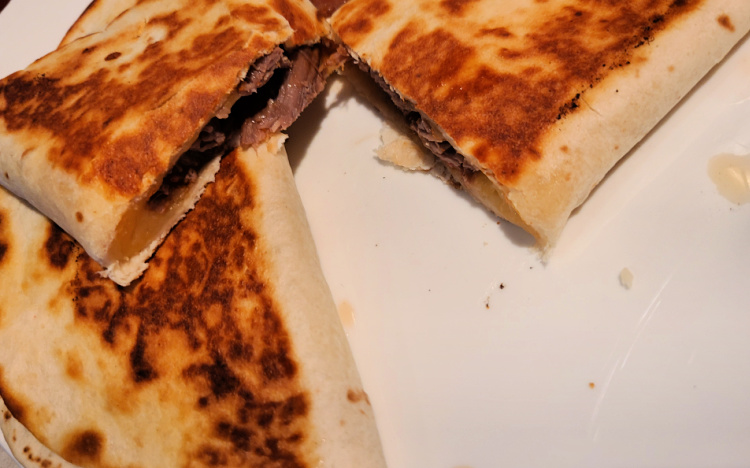Brisket Quesadilla cooked on blackstone served on white plate