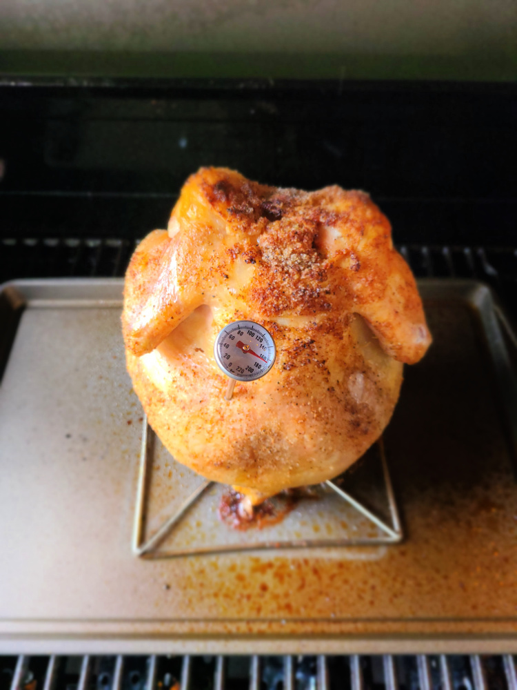 Coke Can Chicken cooking on the grill with food thermometer 