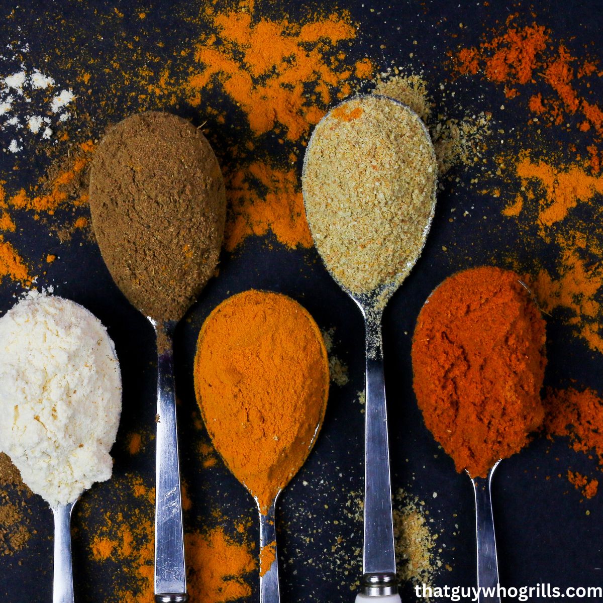 Spices on spoon on a black background