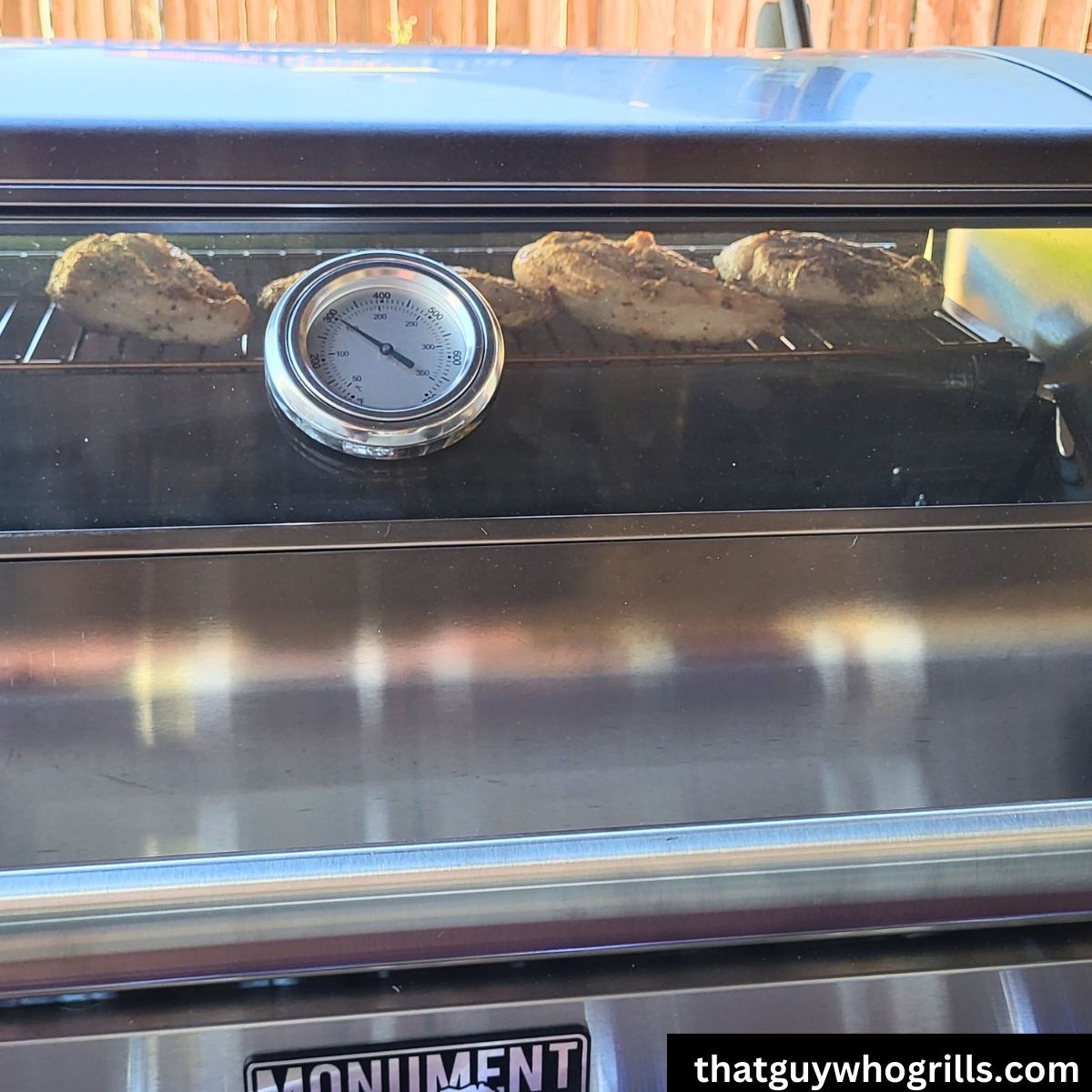 Chicken cooking on Monument Grills Stainless 35633 thru glass on lid