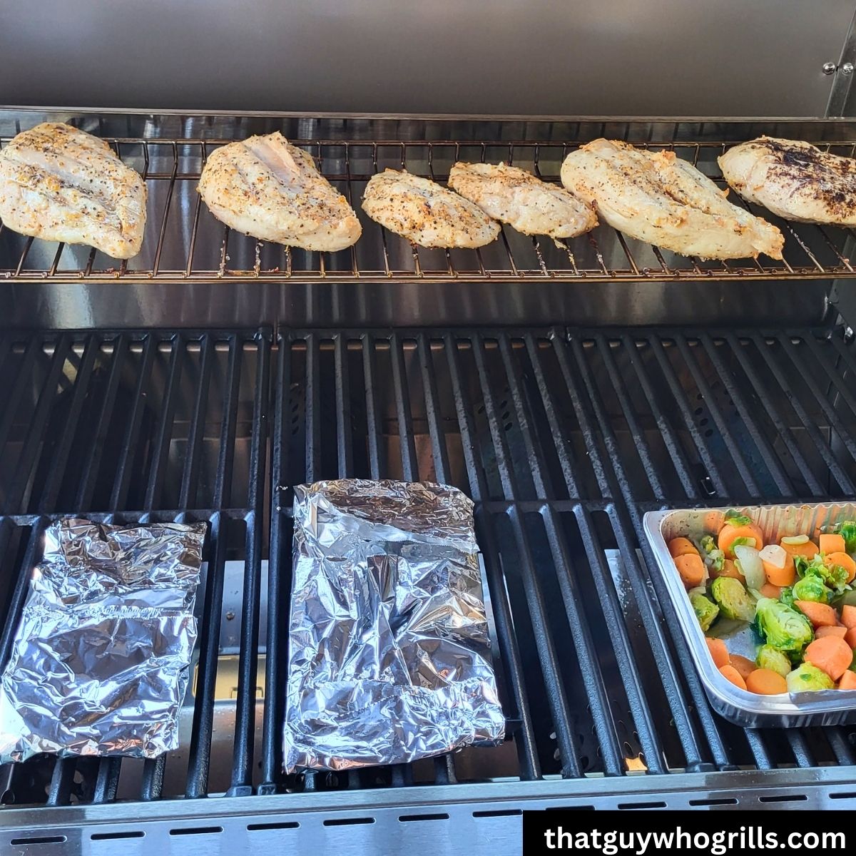 Grilled tilapia foil packets on monument grill with grilled vegetables and chicken breasts