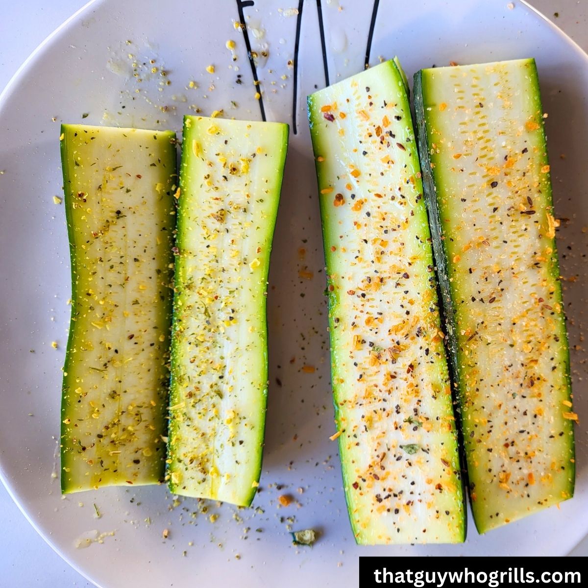 Sliced zucchini sliced on plate seasoned to grill